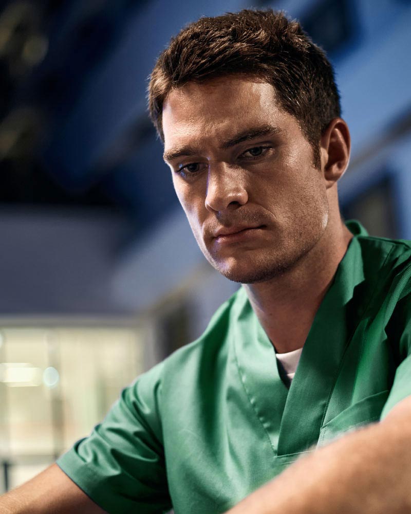 Exhausted nurse sitting in front of a hospital